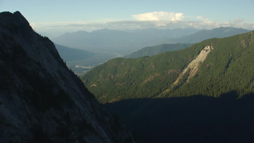 Mountains covered with trees and peaks high in the sky
