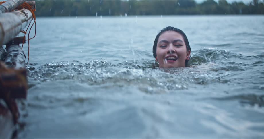 Happy couple swimming in a lake playing and laughing