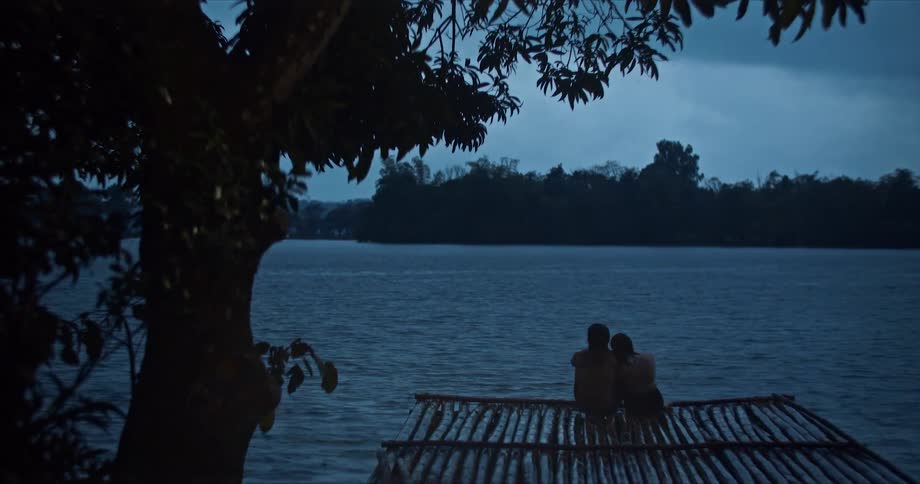 A couple sit together on the pier