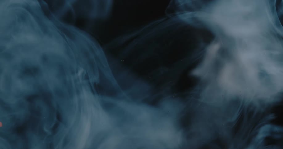 Orange sparks flying in white smoke on a black background