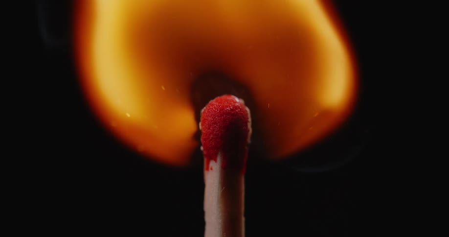 A flame rises from the top of a match