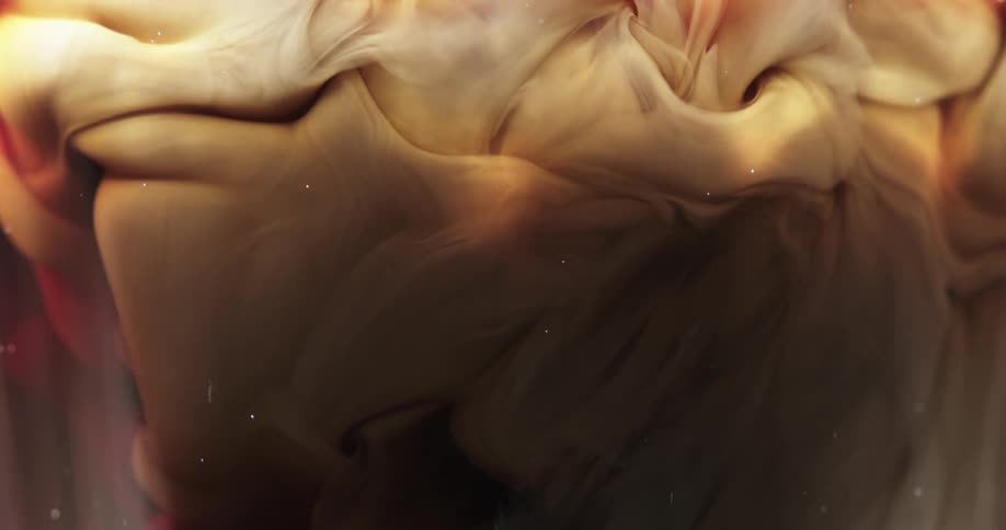 Colorful red and yellow ink flowing and swirling underwater