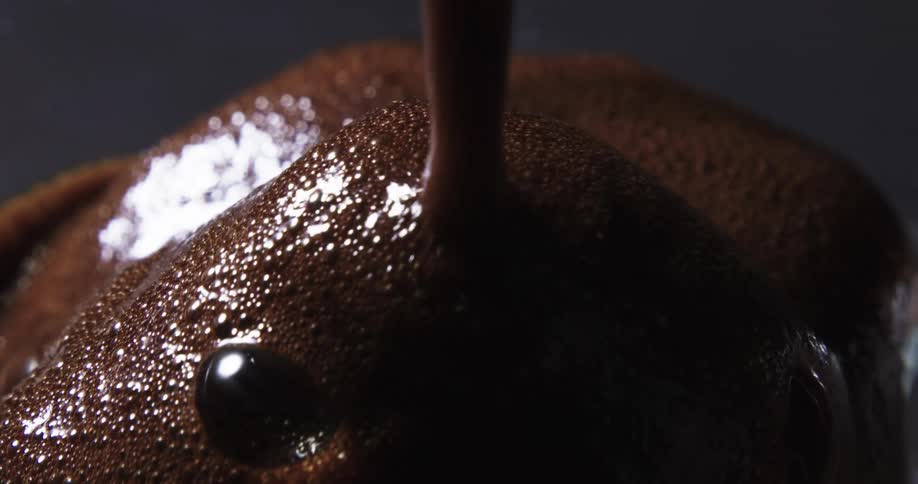 Close up of a brown liquid falling on ice