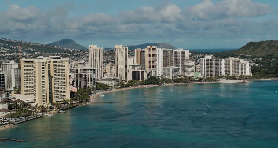 An aerial view of hotels on the shore and waves rippling through the water