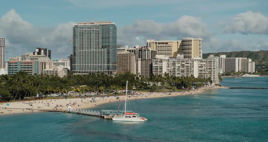 Aerial view of a beach next to a city is displayed