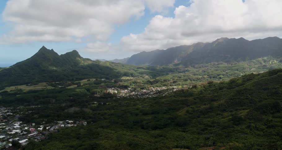 Mountain valley community with mountains and peaks high in a cloudy sky