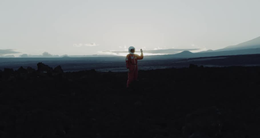 A person in a spacesuit on a landscape with the sky and clouds in the background