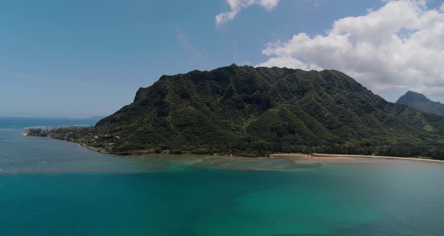 Aerial view of ocean water near mountains is displayed