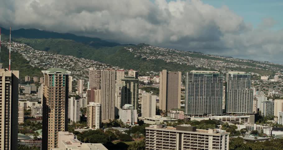 Clouds hover in the distance behind towering rows of skyscrapers