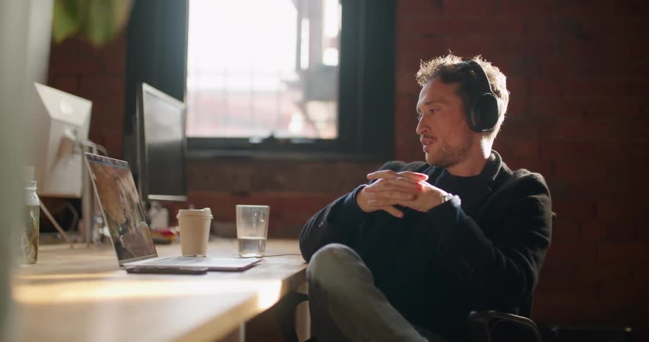 A man sits with his laptop while he has a video conference
