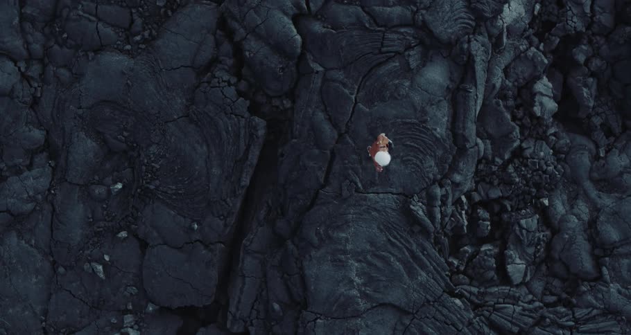 Aerial shot of a person walking on a large rock formation