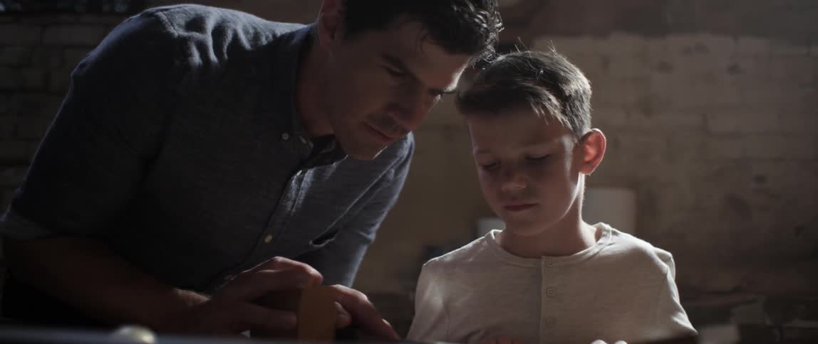 A man talks to a child as they work