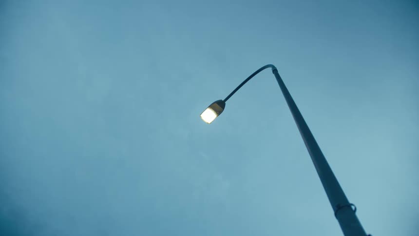 Illuminating street lamp against the cloudy sky