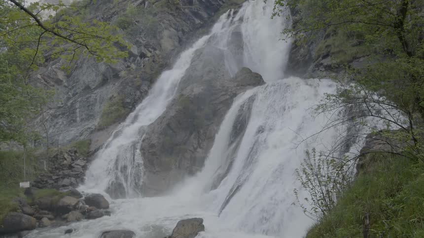 A waterfall down the side of a mountain during the day
