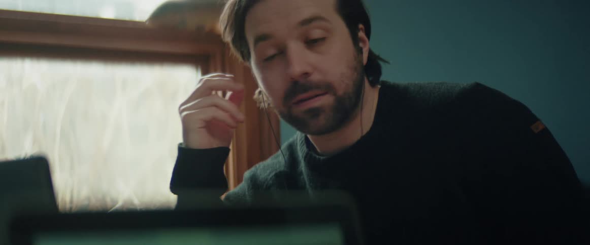 A bearded man on a teleconference via his laptop is interrupted by someone else