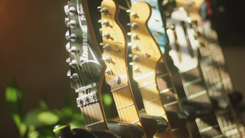 Close up of several guitars on a stand