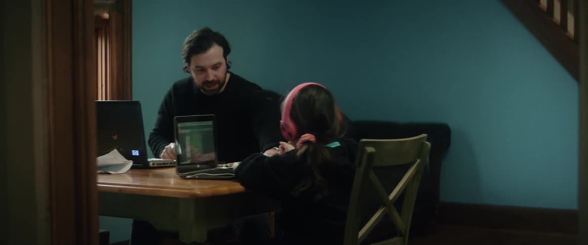 Father and daughter are sitting at a table together