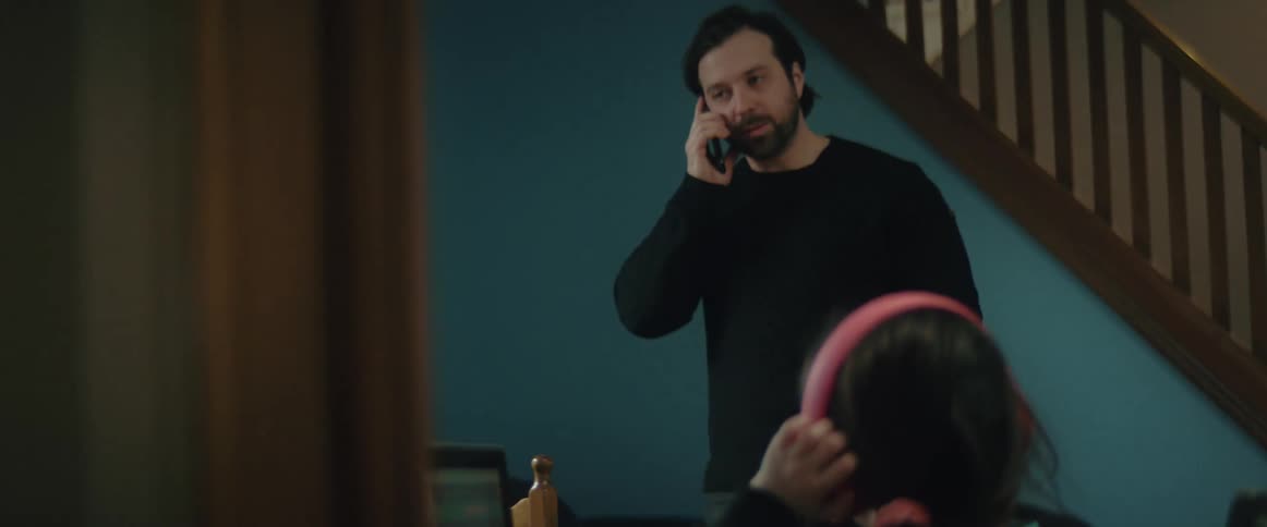 A man talks on his cell phone while a little girl is looking at her