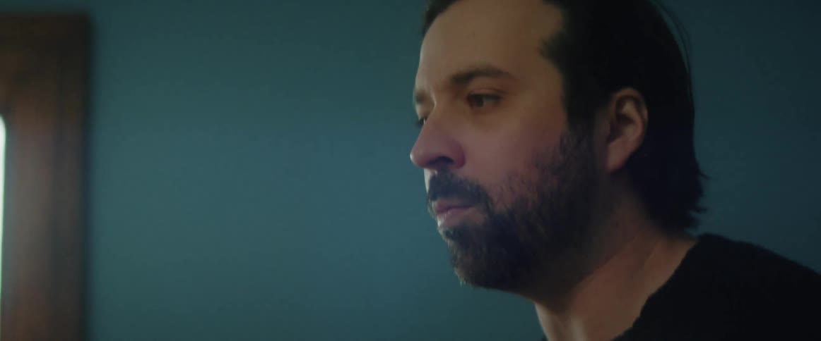 A man walking around in a house with a phone