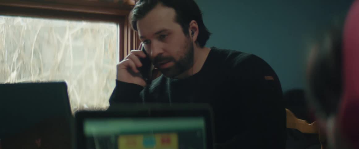 A man talks on his cell phone and uses his laptop and then talks to a child