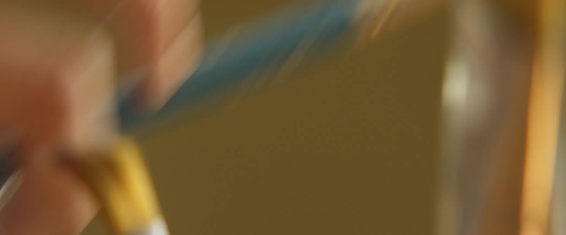A hand picks up an art paint brush