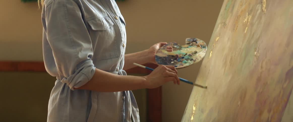 A woman paints on a canvas