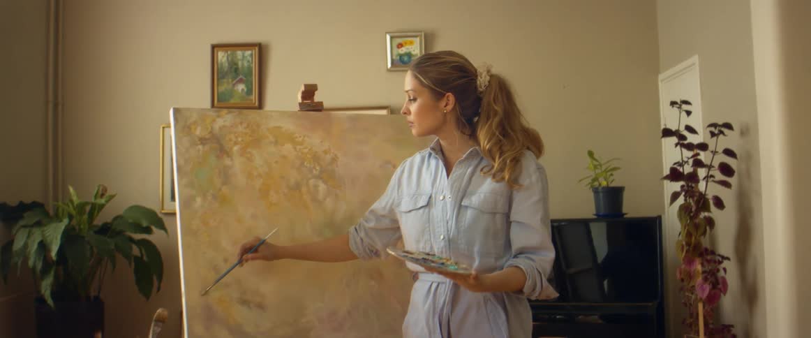 A woman at home paints on canvas