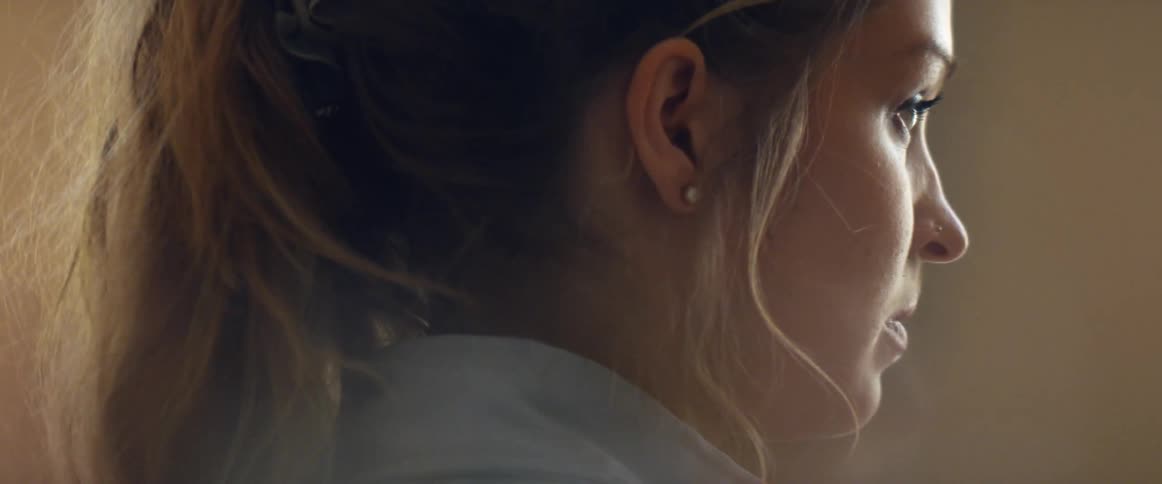 A woman in a room with a wall in the background