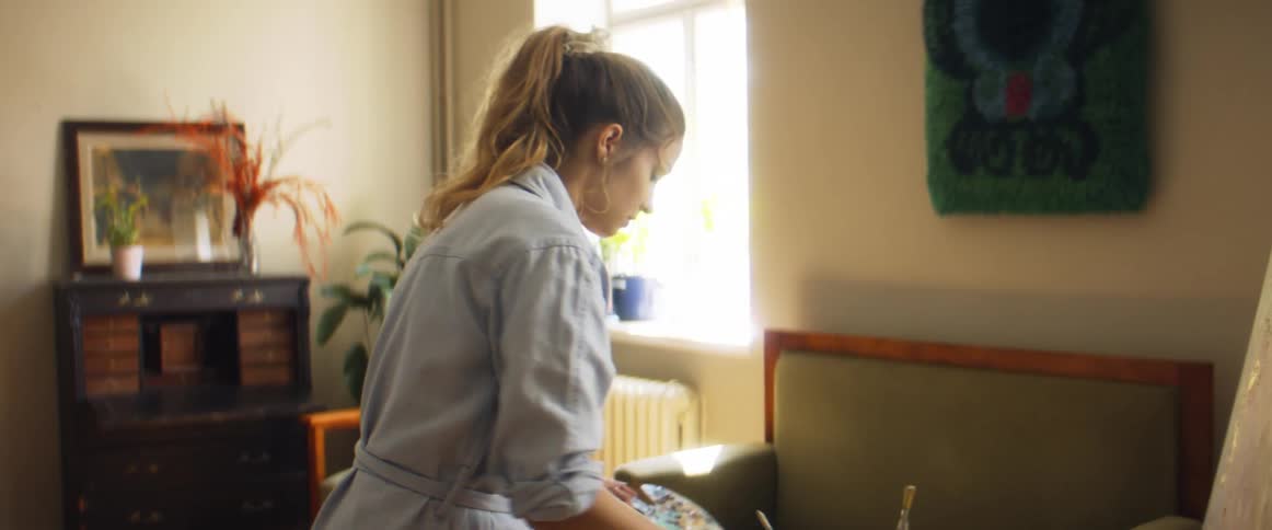 A woman is painting in her living room