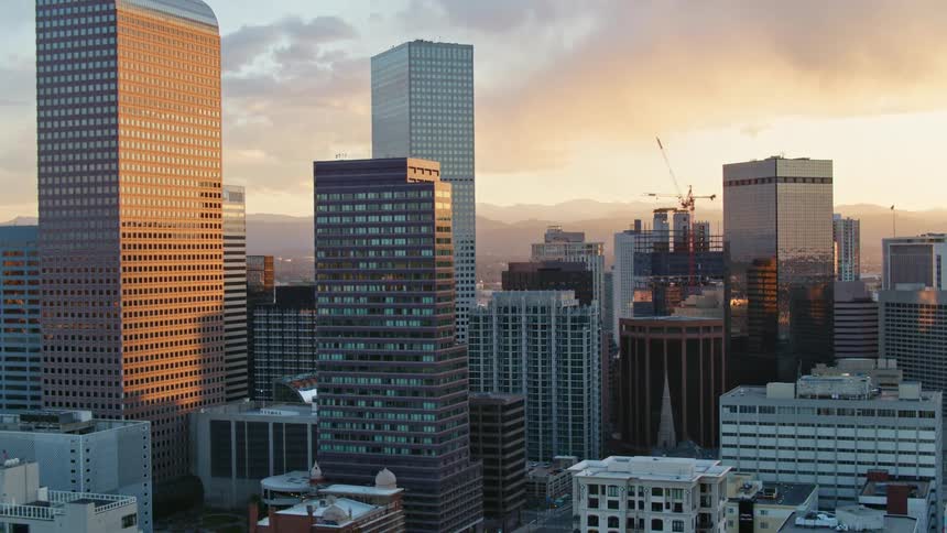 A city skyline with buildings and roads with the sky and clouds in the background