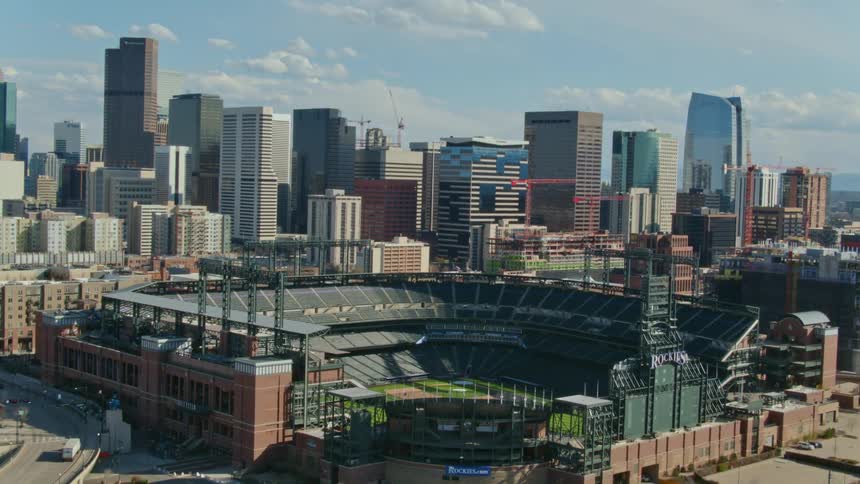 Semi truck moves along freeway past baseball stadium near downtown