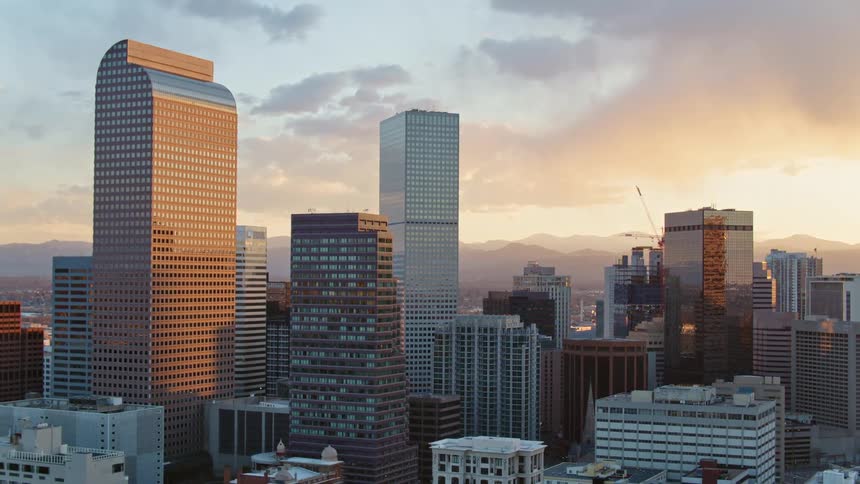 The sun shines on and reflects off city skyscrapers