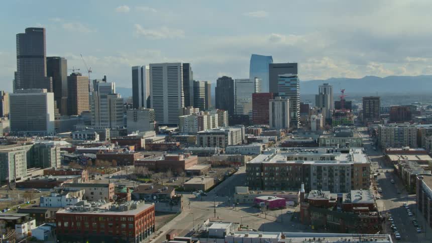 A city skyline with buildings and roads with the sky and clouds in the background