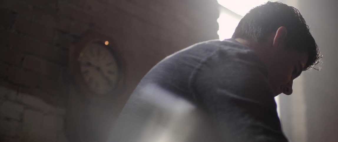A man is working in a shop with a clock on the wall