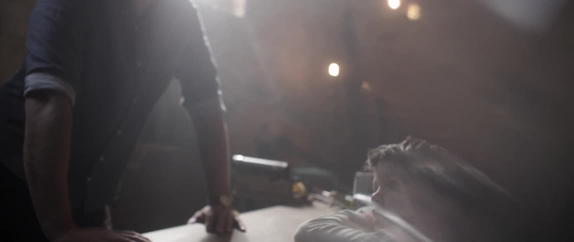 A boy and man are leaning against a workbench