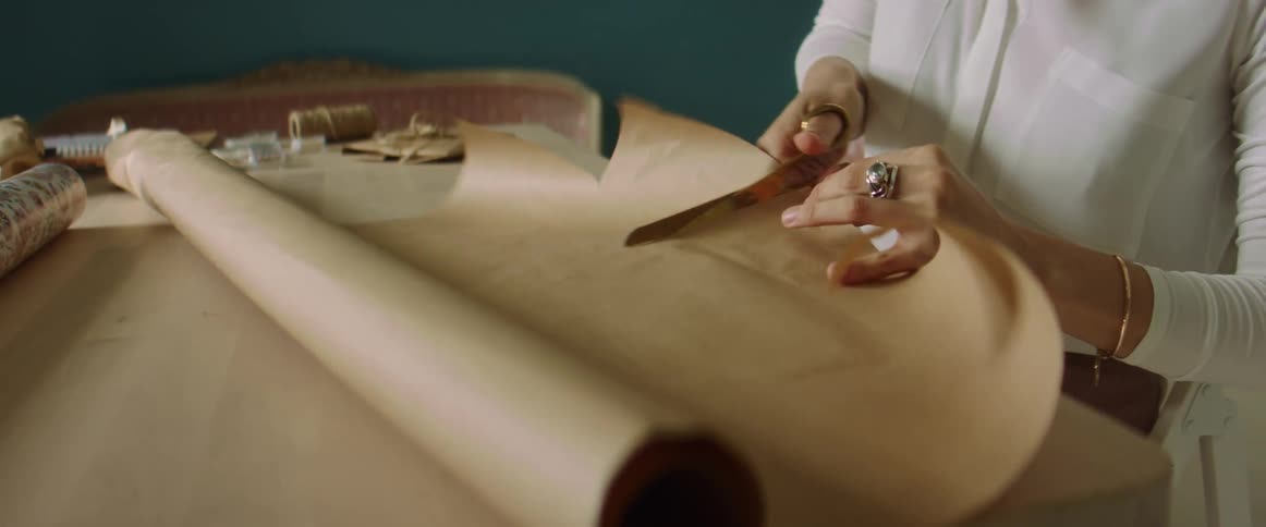 A woman cutting a piece of paper on a table