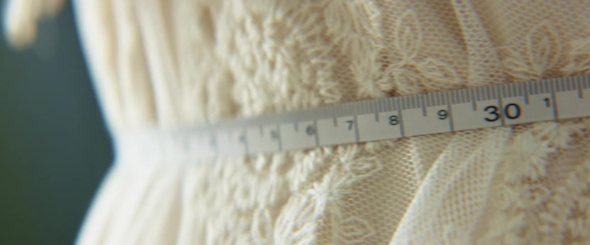 Close up of a measuring tape against a laced cloth
