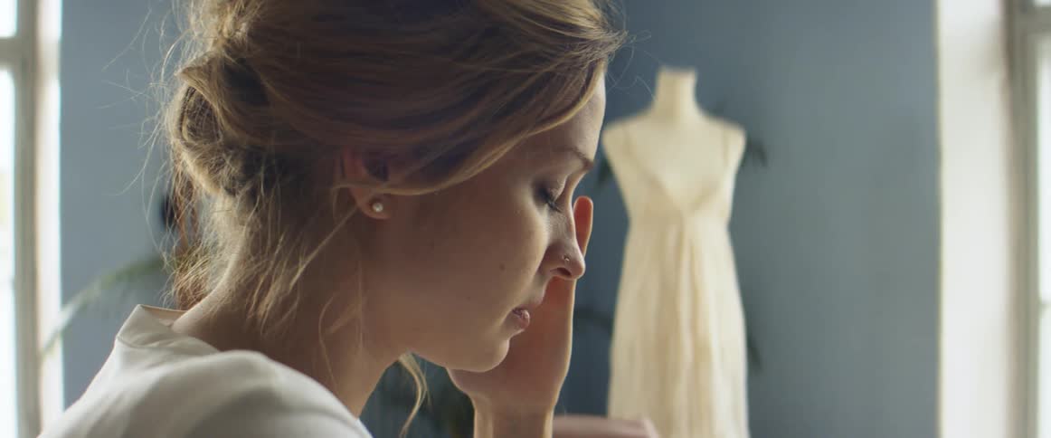 A woman rubs her face as she is working