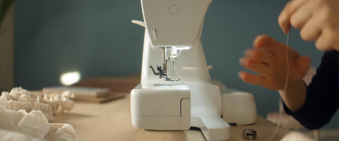 A close up of a person using a sewing machine