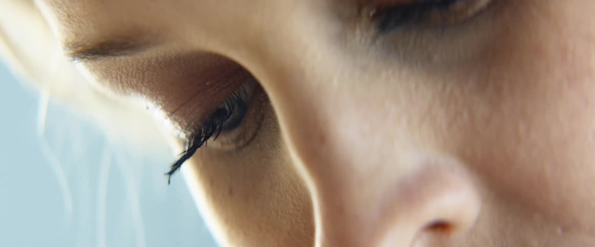 A woman looks down as she blinks