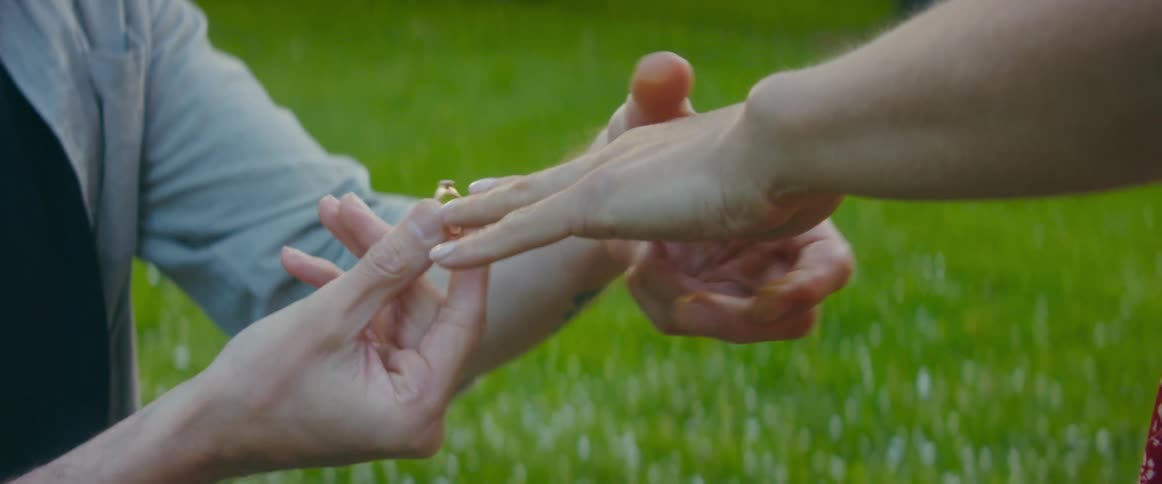 A man is proposing to his girlfriend outdoors in spring
