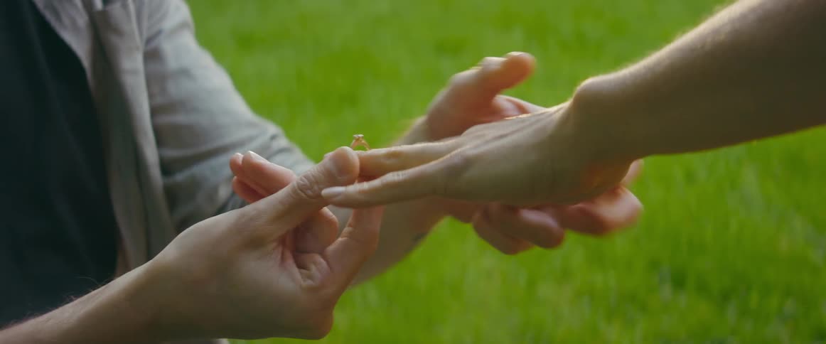 A man is proposing to his girlfriend outdoors in spring