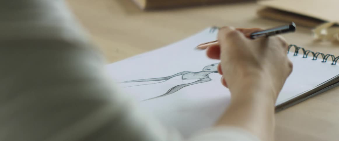 Close up of pencil sketch of a dress being made