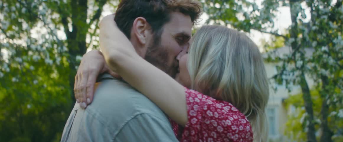 A boyfriend and girlfriend kissing outdoors