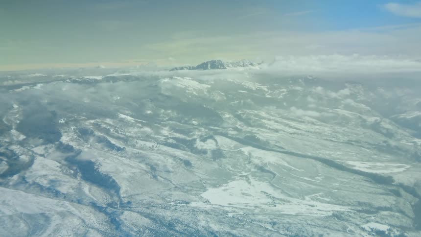 A landscape with snow and ice with a mountain range the sky and clouds in the background