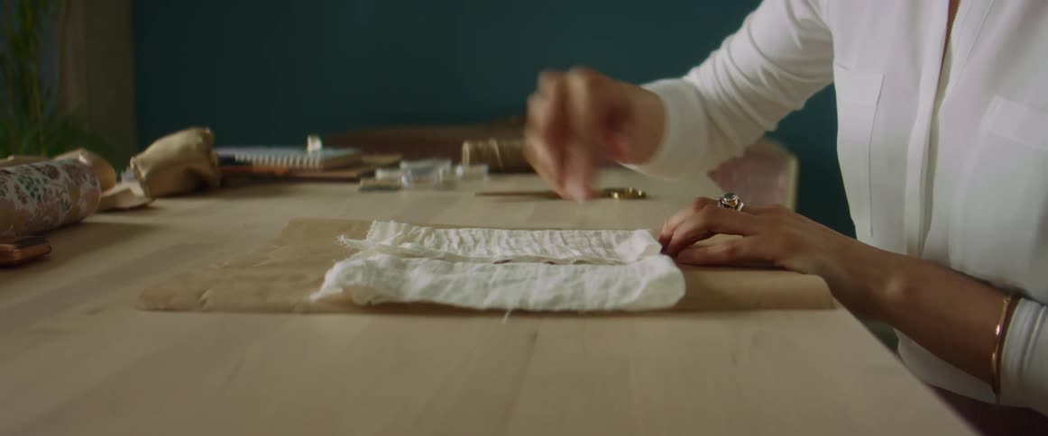 A woman putting jewelry in a piece of cloth