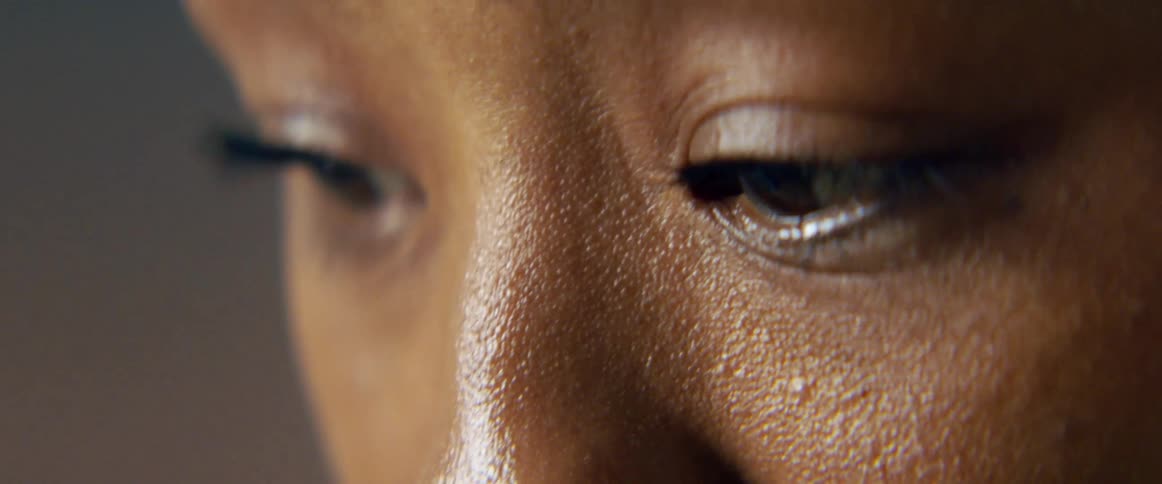 An asian person focuses their gaze at something while the camera captures their eyes from up close