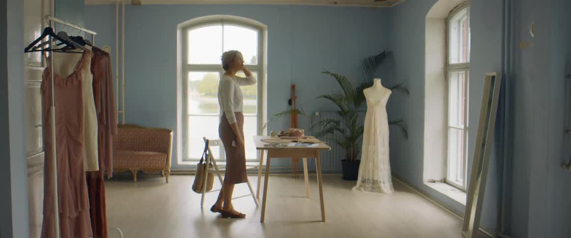 Fashion designer arriving at her studio sits at the desk