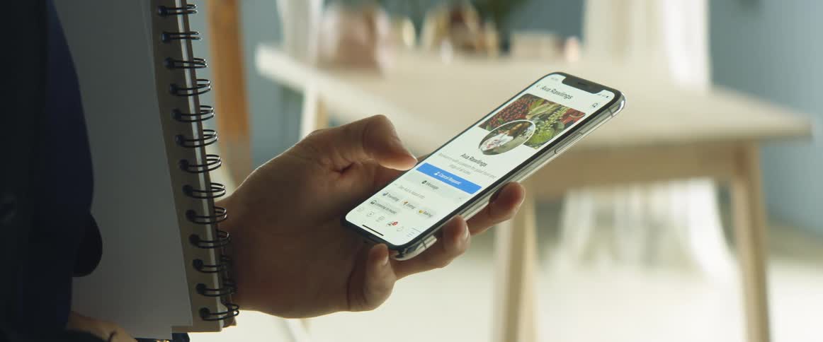 A woman taps and scrolls on her phone with her thumb before turning the screen off
