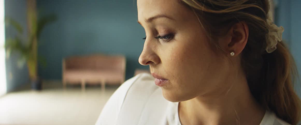 A woman sitting indoors concentrates on the task that she is working on